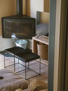 Mesa baja de metal y cesto junto al mueble del televisor