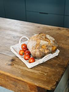 Pan de payés y tomates en una bandeja sobre una mesa de madera
