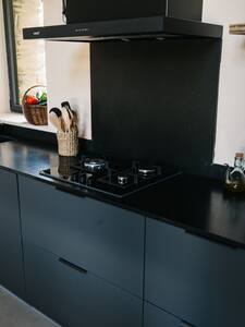 Placa de cocina y utensilios sobre una encimera negra