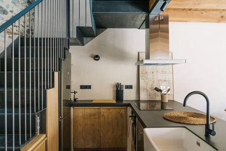 Cocina con fregadero de cerámica bajo la escalera