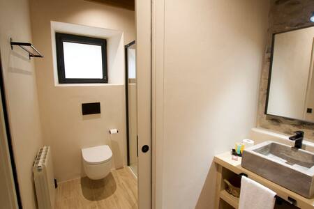 Baño con inodoro, radiador y ventana