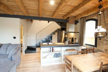 Salón comedor con cocina, escalera y techo de madera