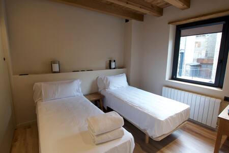 Habitación con dos camas individuales y ventana