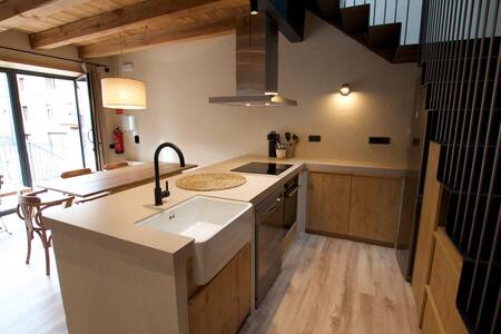 Cocina con fregadero, placa y campana bajo la escalera